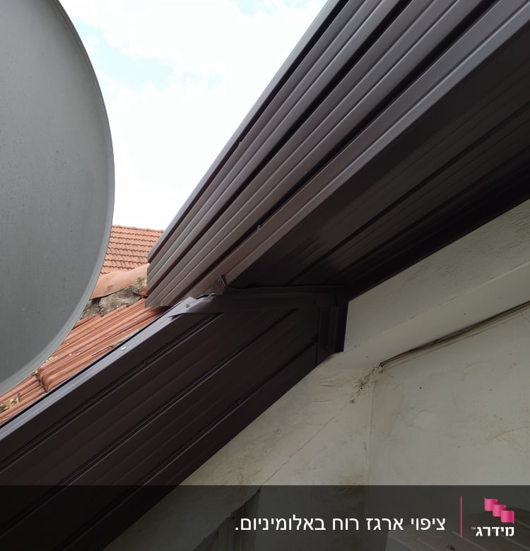 גג מתכת חום עם צלחת לוויין בצד